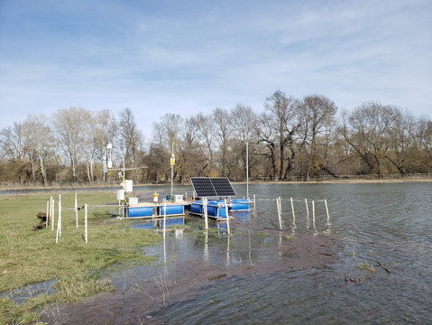 Schwimmende Messstation im überschwemmten Augebiet. Messplattform auf schwimmenden blauen Kunststoffbehältern.