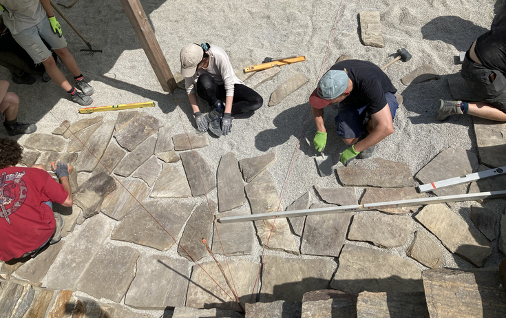 Foto von oben: Studierende beim Verlegen von Natursteinplatten