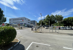 Large paved parking lot with office building in the background