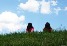 two girls sitting on grass