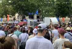 Many people on the Ringstrasse, with the University of Vienna in the background.