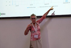 Dr. Stangl points to a diagram on the large monitor.