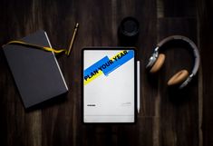 A tablet with "plan your year" writing, notes and headphones
