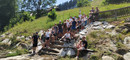 Im Tal. Die Gruppe kommt zu einem größeren Wildbach mit massiven Schutzbauwerken aus Stein und  Beton.