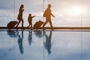 Silhouette of young family with luggage walking at airport