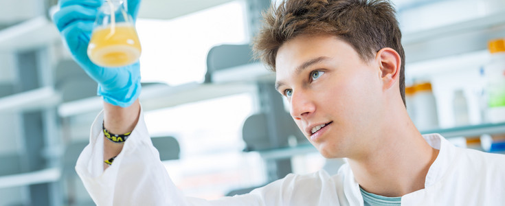 Young man conducts an experiment in the laboratory.