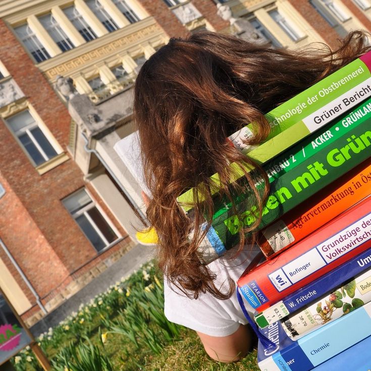 Symbolfoto Girl laying against books