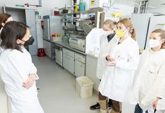 5 Personen in weißen Labormänteln im Labor für Mikrobiologie