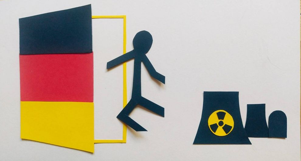 Scherenschnit: Person geht durch eine halb offene Tür, in den Farben der deutschen Flagge, weg von AKWs