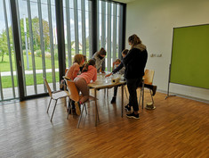 Kinder rund um einen Tisch bei der Kinder UNI Tulln 