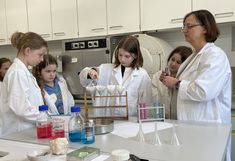 Workshopleiterin und Teilnehmerinnen bei Farbexperiment im Tonmineral Labor