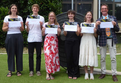 Gruppenfoto der fünf BOKU-Studierenden, die gemeinsam mit ihrem Lehrleiter Wolfgang J. Berger im Freien auf einer Wiese stehen und lächelnd ihre offiziellen Teilnahmebestätigungen des Workshops „City & Traffic“ präsentieren.