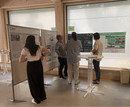 Vier Personen stehen vor den Plakaten und diskutieren