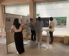 Vier Personen stehen vor den Plakaten und diskutieren