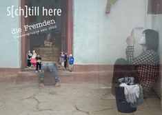 Man sieht eine Schrift mit dem Titel des Stücks S(ch)till here und den name der Theatergruppe "Die Fremden". Im Hitergrund sitzte ein Mädchen auf einer Stiege und hält eine Kiste. Um sie herum stehen 6 Personen, die viel kleiner sind als sie. In der rechten Hälfte des Bildes sitzt eine Person (sehr vie größer als die anderen) mit dem Handy auf dem Boden. Die Person ist leicht transparent