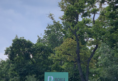 A large green sign with the Boku logo and the inscription "BOKU University" is held up in front of the university.