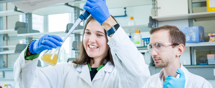 Young woman carries out an experiment in the laboratory.