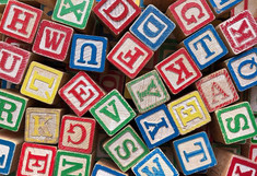 verschiedene bunte Holzwürfel mit Buchstaben drauf, durcheinander gemischt 