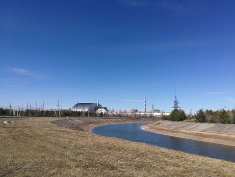 AKW Tschernobyl mit Fluß im Vordergrund bei blauem Himmel